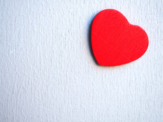 Red heart on white wooden background with copy space.