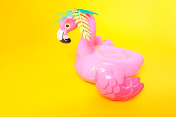 Inflatable pink flamingos on a bright yellow background.