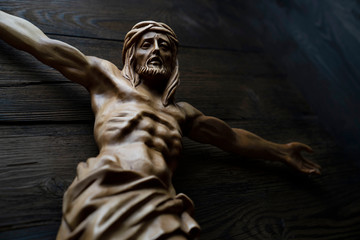  Cruciefied Jesus figure isolated on rustic dark brown table.