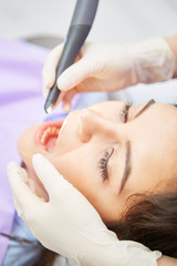 Obraz na płótnie Canvas Dentist treats patient with the drill