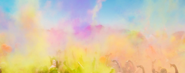Obraz na płótnie Canvas Crowd throwing bright colored powder paint in the air at Holi Festival Dahan