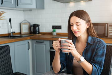 Girl in a shirt with coffee in hand.