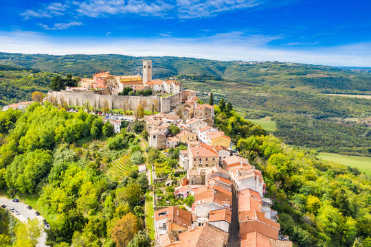 Fototapeta Beautiful old town of Motovun, stone houses and church tower bell, romantic architecture in Istria, Croatia, aerial view from drone
