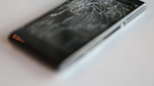 Broken phone glass. broken black smartphone. Close up on white background