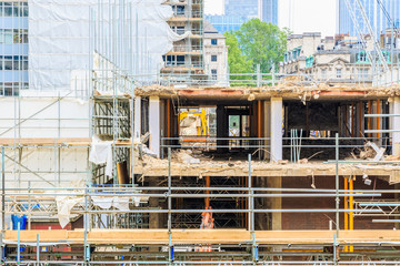 Building constriction site with scaffolding, cranes and industrial unites in London
