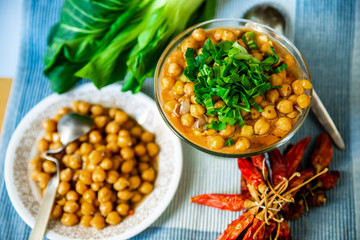 Boiled chickpeas, dried red chilli peppers on blue table.