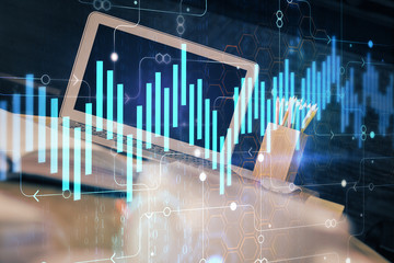 Financial chart drawing and table with computer on background. Double exposure. Concept of international markets.