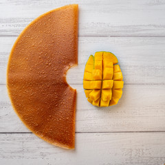 Colorful mango fruit leather and fresh mango on light background