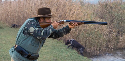 Hunting period, autumn season open. A hunter with a gun in his hands in hunting clothes in the...