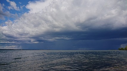 Obraz premium Dramatic thunderstorm clouds forming over a lake