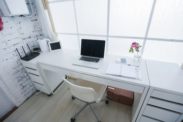 Modern interior workplace with laptop in white colors.