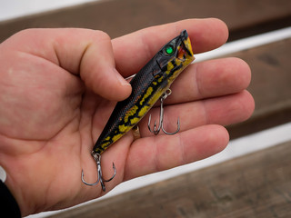 Fishing lures and accessories in the box background. Focus in the center of the bait.