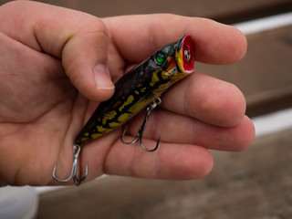 Fishing lures and accessories in the box background. Focus in the center of the bait.