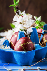 Easter eggs and spring white flowers on Easter blue background with copy space