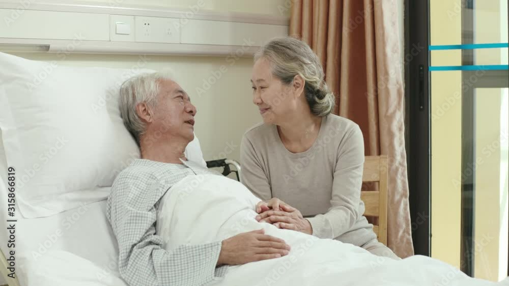 Sticker asian old woman visiting elderly husband talking and kissing on forehead in hospital ward