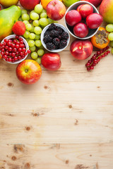 Healthy colorful fruits berries on wooden pine table, top view, copy space, selective focus
