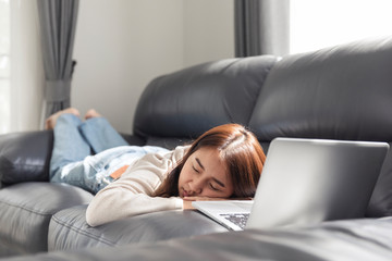 Young woman doing research work for her business, Smiling woman on sofa relaxing while browsing online shopping website.