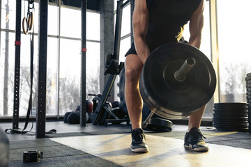 Best choice. Young muscular caucasian athlete training in gym, doing strength exercises, practicing, work on his upper body with weights and barbell. Fitness, wellness, healthy lifestyle concept.