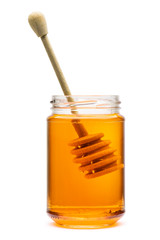 Honey wooden dripper inside glass jar, on white background