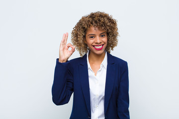 young woman african american feeling happy, relaxed and satisfied, showing approval with okay...