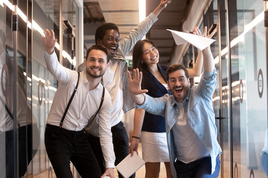 Funny multiethnic employees posing for picture in office hallway