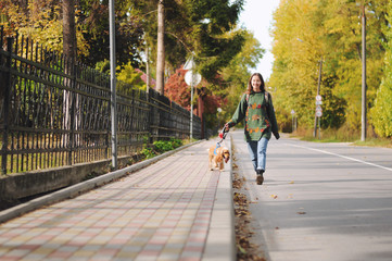woman with american cocker spaniel walks at autumn park