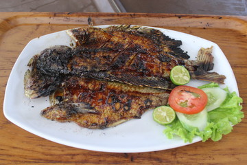 Grilled fish with vegetables on a white plate