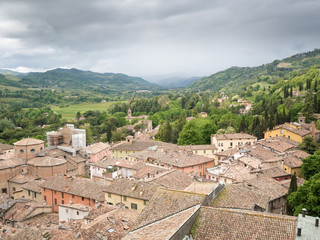 Fototapeta na wymiar Brisighella, Ravenna, Emilia Romagna, Italy: Roofs from the top. The fortress, The Clock Tower and Monticino church charaterize the landscape for wich Brisighella is famous.