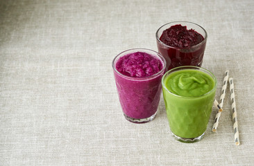 Various vegetable smoothies on a gray background