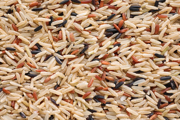 Mix of different brown rice as background, top view