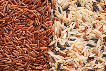 Mix of different brown rice as background, top view