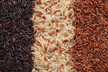 Different types of brown rice as background, top view