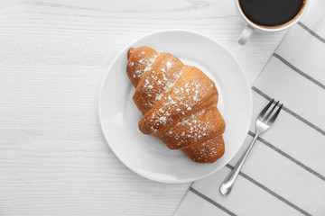 Delicious croissant and morning coffee on white wooden table, flat lay