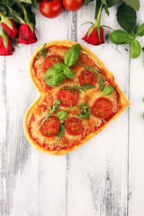 pizza Heart shaped margherita with tomatoes and mozzarella vegetarian. Food concept of romantic love pizza for Valentines Day.