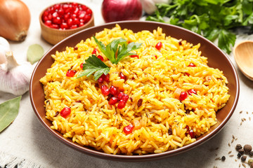 Tasty rice pilaf with pomegranate grains on table, closeup