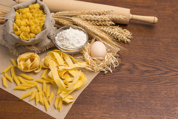 Fototapeta na wymiar Organic food. Durum wheat pasta. Eggs and flour, rolling pin and sprigs of wheat .
