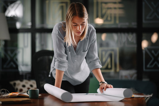 Young businesswoman working on project. Beautiful architect in office. 