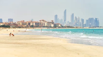 Poster Saadiyat zandstrand met de skyline van Abu Dhabi aan de horizon © vladimirzhoga