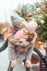 Fototapeta premium Adorable girls skating on ice rink outdoors in winter snow day