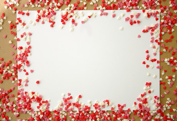 Sugar red hearts frame with white paper, space for text. Romantic, Valentines day concept. Top view. Backdrop with sweets.