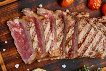 Keto ketogenic diet grilled fried beef steak, striploin on cutting board on dark brown table