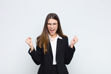 young businesswoman feeling happy, positive and successful, celebrating victory, achievements or...