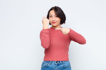 young pretty woman looking impatient and angry, pointing at watch, asking for punctuality, wants to...