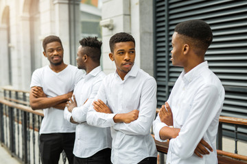 four handsome young african men in white shirts