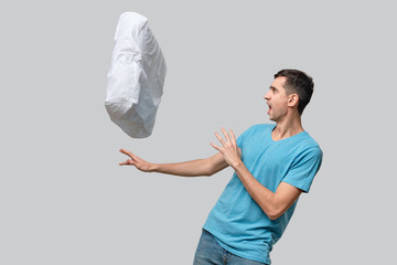 White pillow flying suddenly into pretty brunet man.