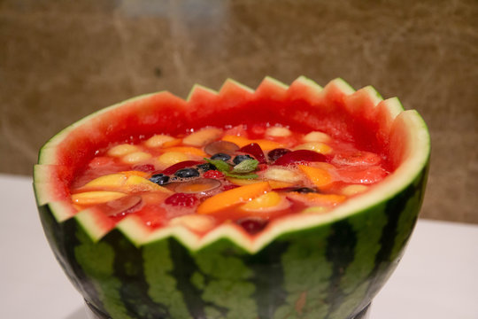 Carving watermelon with cold fruit soup inside. Carved watermelon bowl.