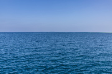 Calm sea ocean and blue sky background. Endless view with horizon and blue tones