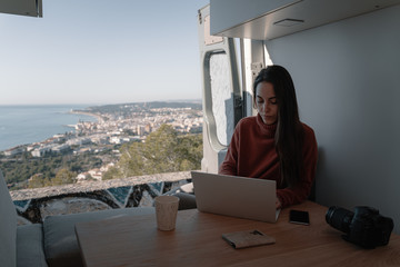 Woman sitting in vehicle looking at view while working