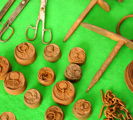 old objects and rusty tools on a green textile background