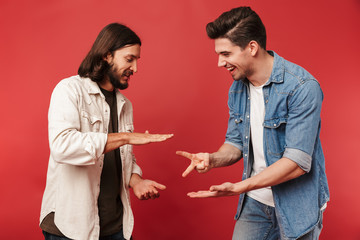 Photo of young smiling guys playing rock-paper-scissors game